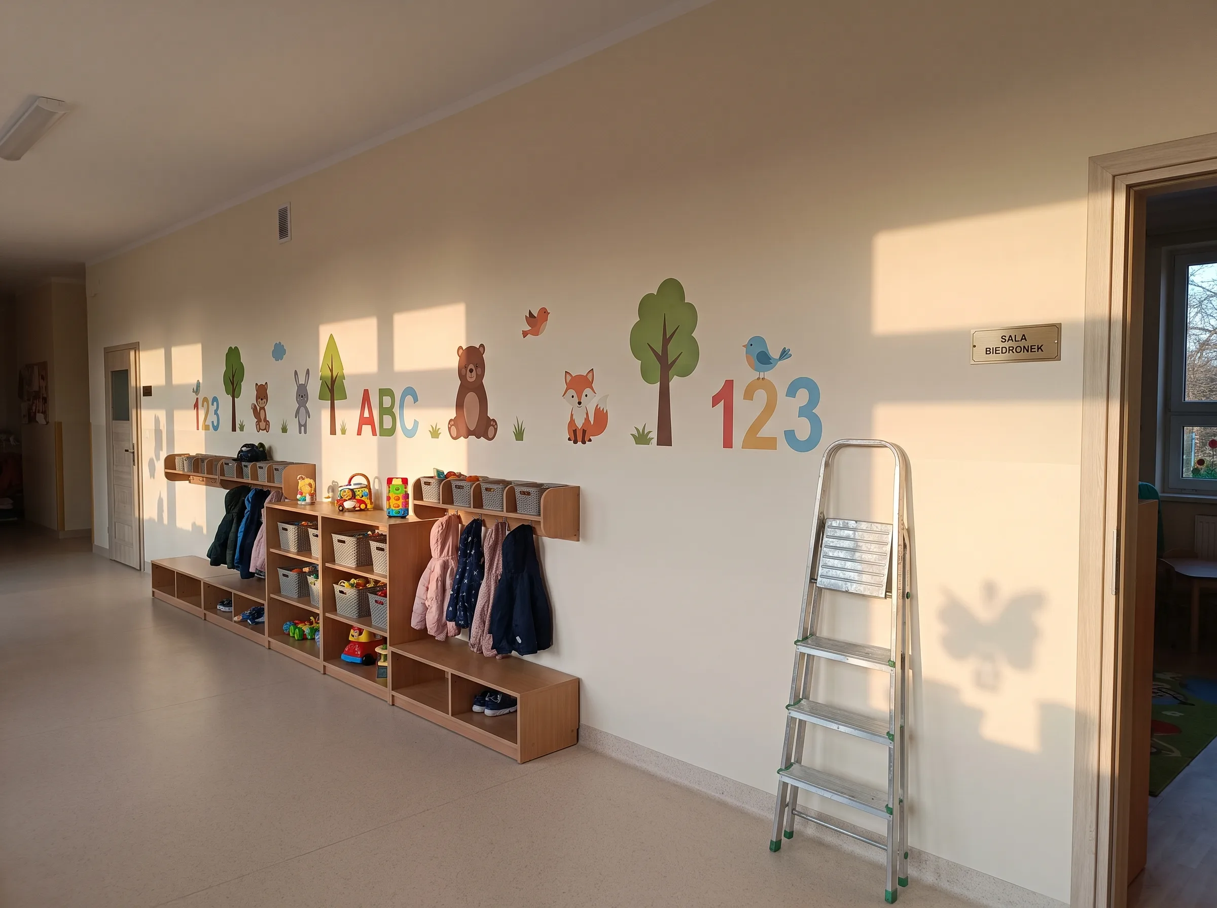 Kolorowy mural edukacyjny z alfabetem, liczbami i zwierząkami na ścianie przedszkolnej