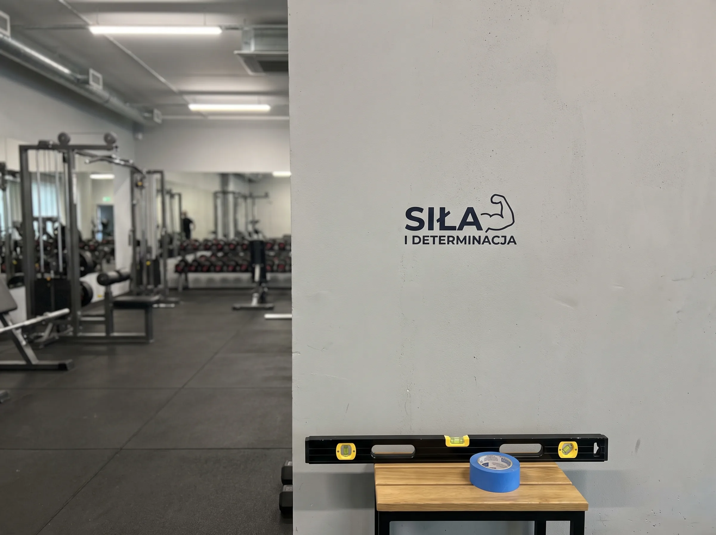 Grafika do klubu fitness na białej ścianie sali treningowej