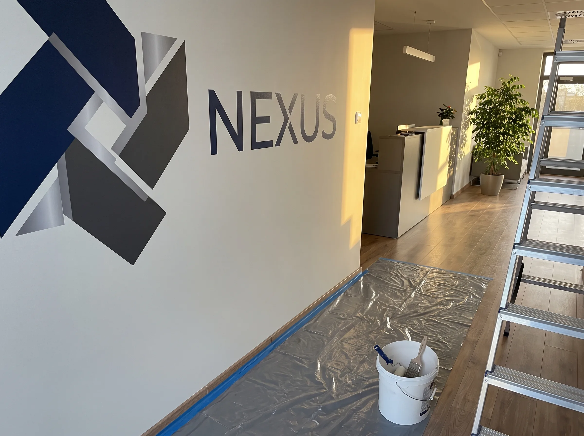 Geometryczne logo i napis NEXUS na białą ścianę - Logo na ścianach i Napisy na ścianach